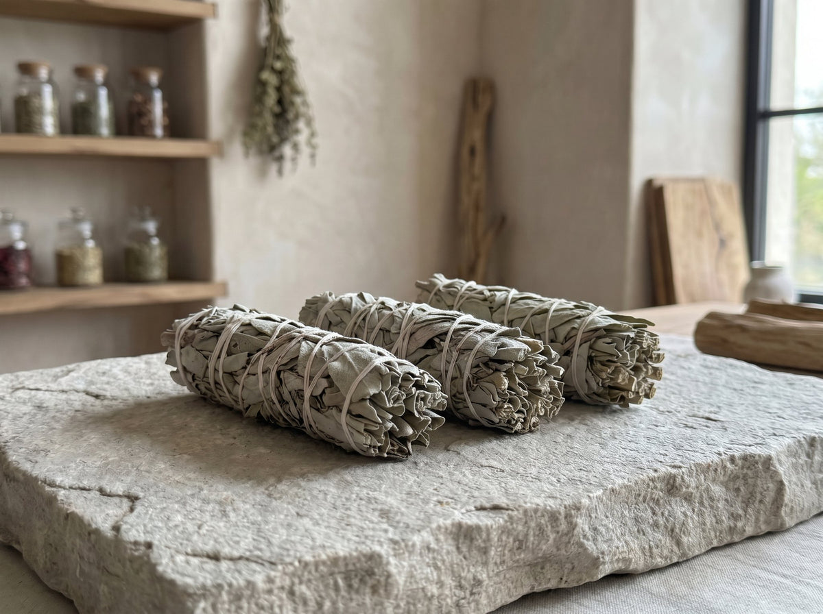Three 4-inch white sage smudge sticks (Salvia apiana) on a natural stone slab