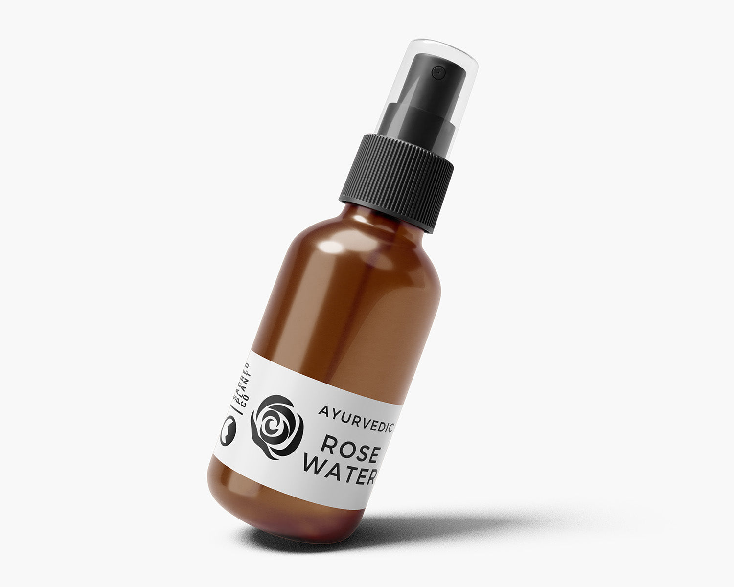 Slightly tilted view of Sacred Plant Co’s Ayurvedic Rose Water spray bottle showing sleek amber glass and labeled white band.