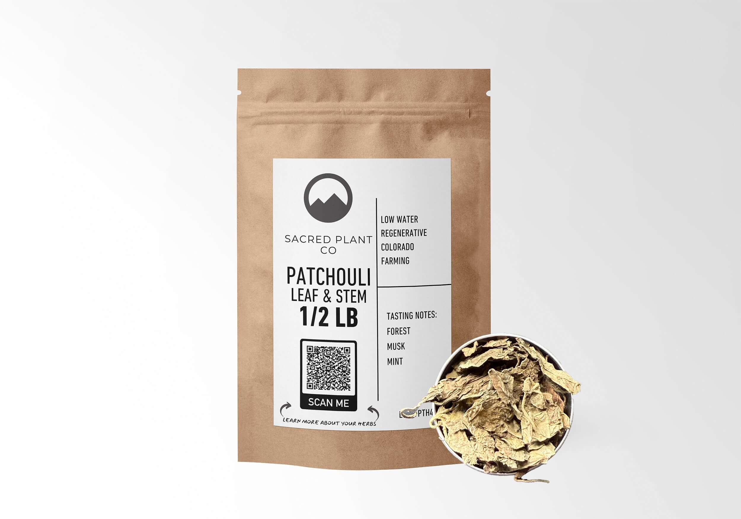 Sacred Plant Co Patchouli Leaf & Stem 1/2 LB kraft paper packaging with sample in silver tin showcasing sustainably grown herb for usage in aromatherapy and wellness practices.