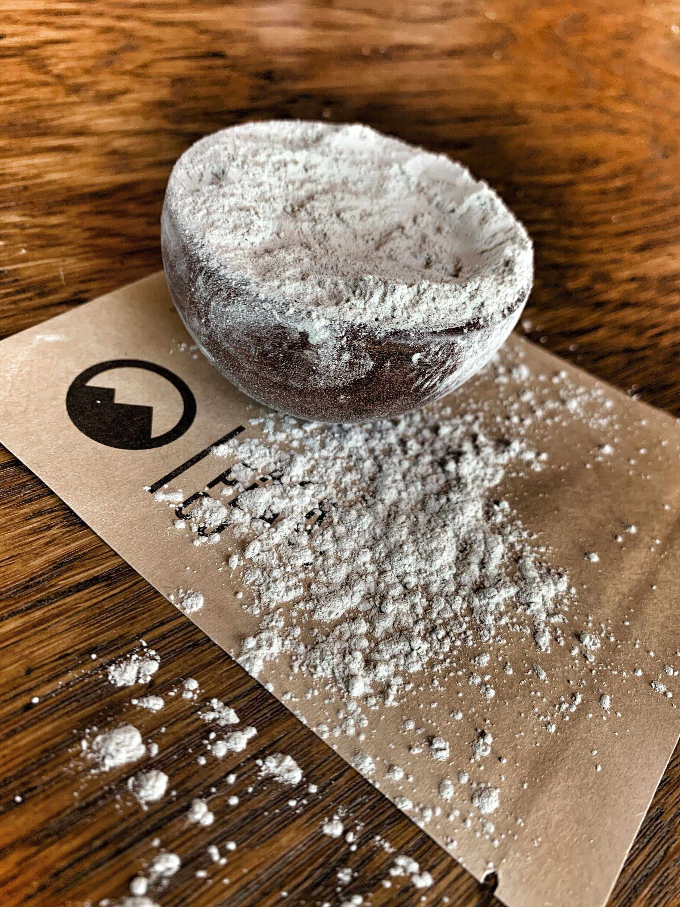 Fine, premium quality light grey Bentonite Clay Powder with natural powdery texture, Sacred Plant Co branding in background, captured from above.