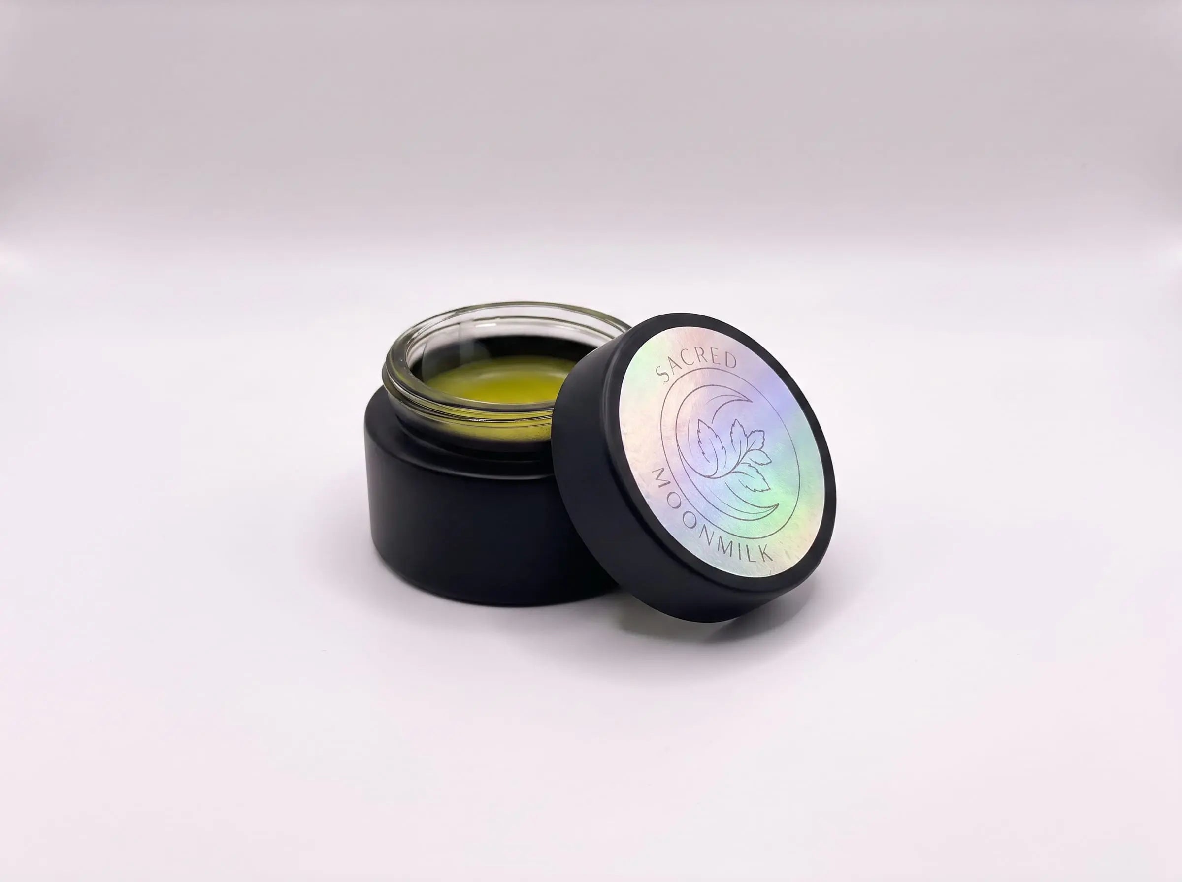 Open jar of Sacred Plant Co Moonmilk Botanical Night Balm showing the soft golden mugwort-infused balm on a clean white background