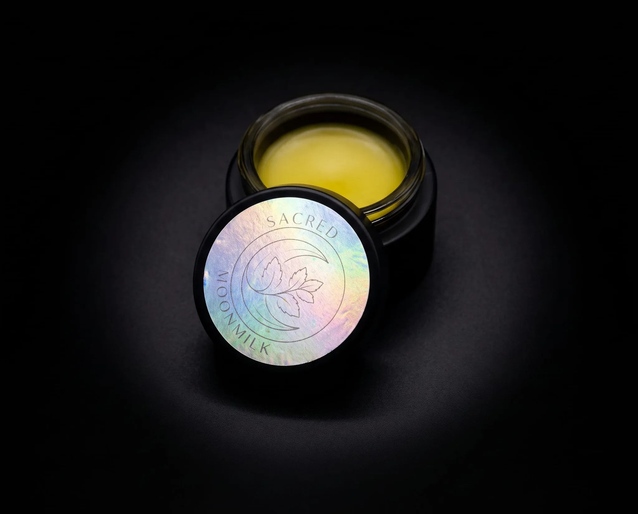 Closed 1 oz (28 g) matte black-lidded glass jar of Sacred Plant Co Moonmilk Botanical Night Balm