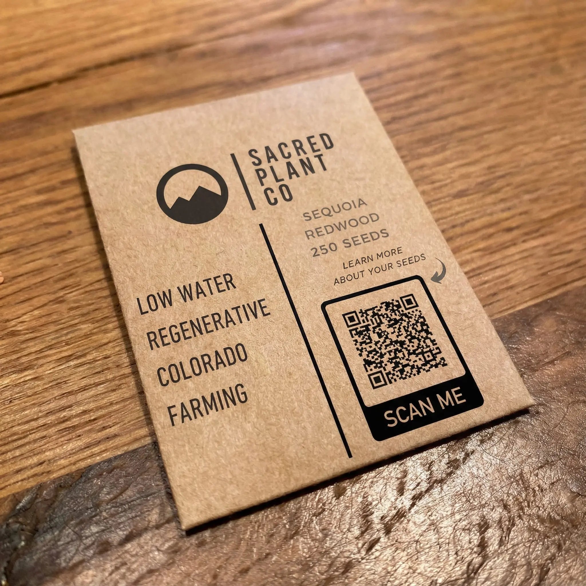 Premium kraft Giant Sequoia seed packet from Sacred Plant Co on wood background.