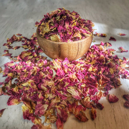 Loose dried rose petals from Sacred Plant Co, displayed in abundance, showcasing the natural variation in color for use in wedding decor and aromatherapy.