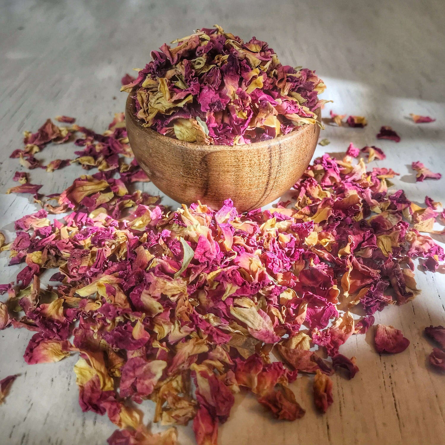 Loose dried Rose Petals from Sacred Plant Co, displayed in abundance, showcasing the natural variation in color for use in wedding decor and aromatherapy.
