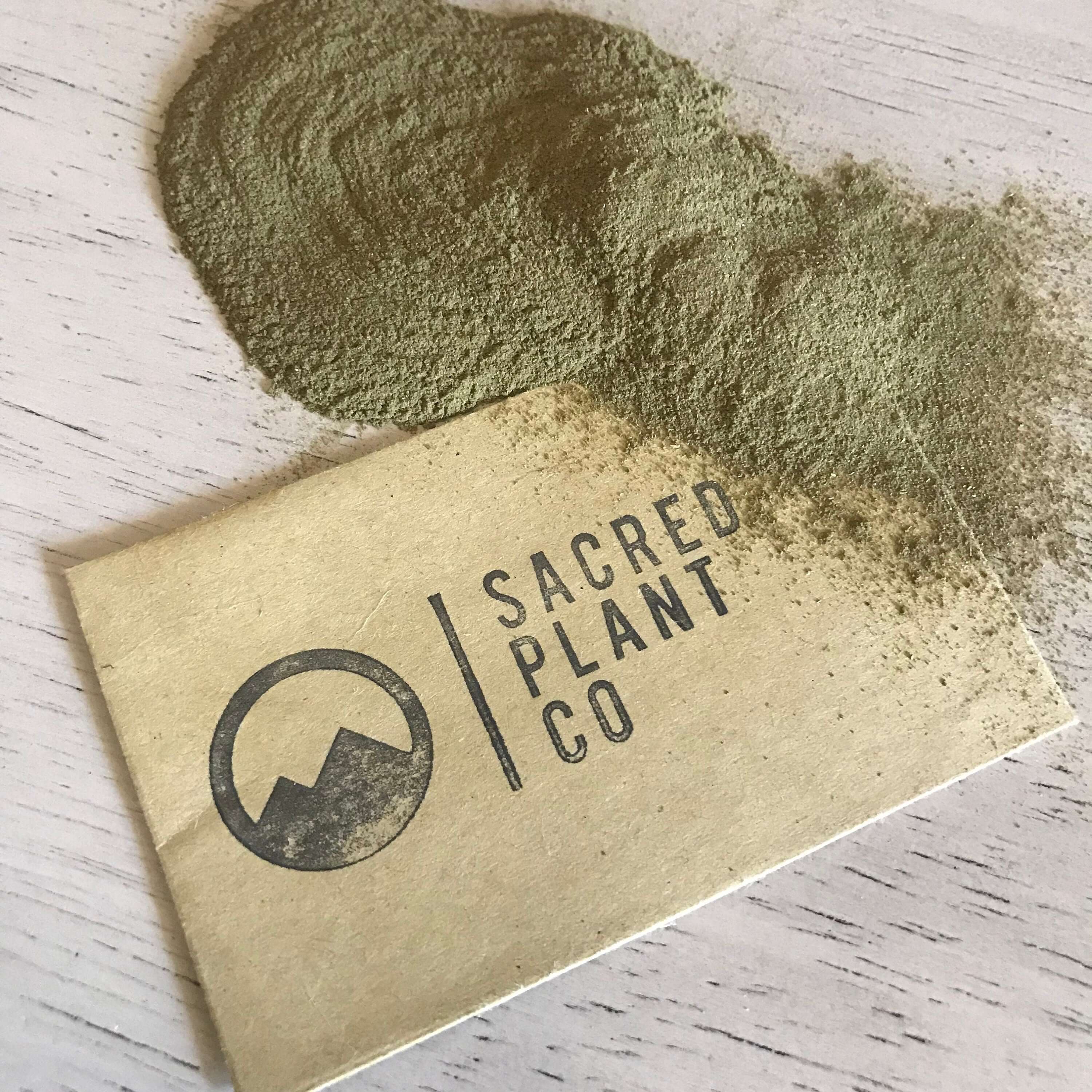 Detailed view of Sacred Plant Co Neem Leaf Powder, showing a finely textured green surface, premium quality branding visible on a white surface.