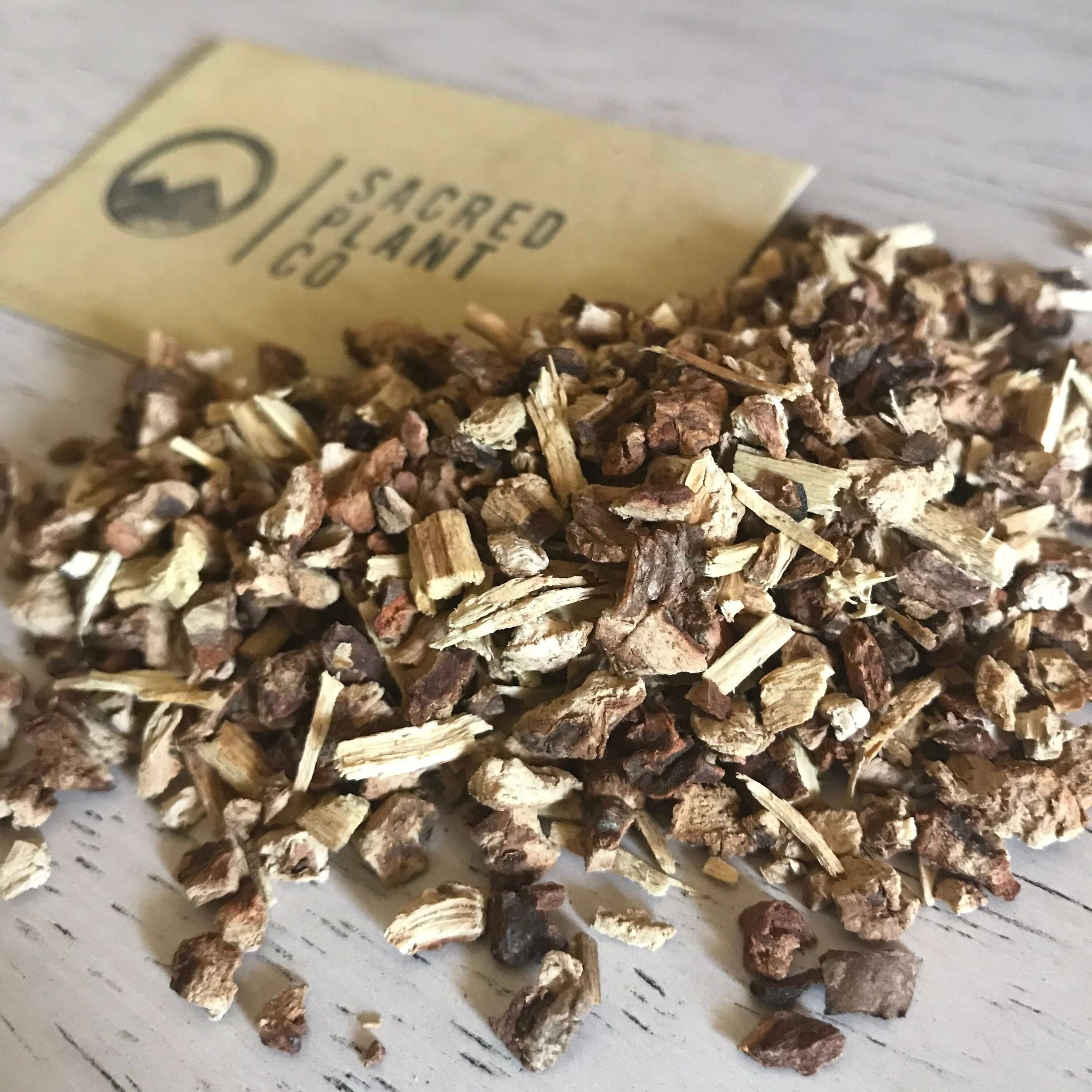 Natural dried Sarsaparilla Root from Sacred Plant Co, in various shades of brown with a rustic, textured appearance on a light wood background.