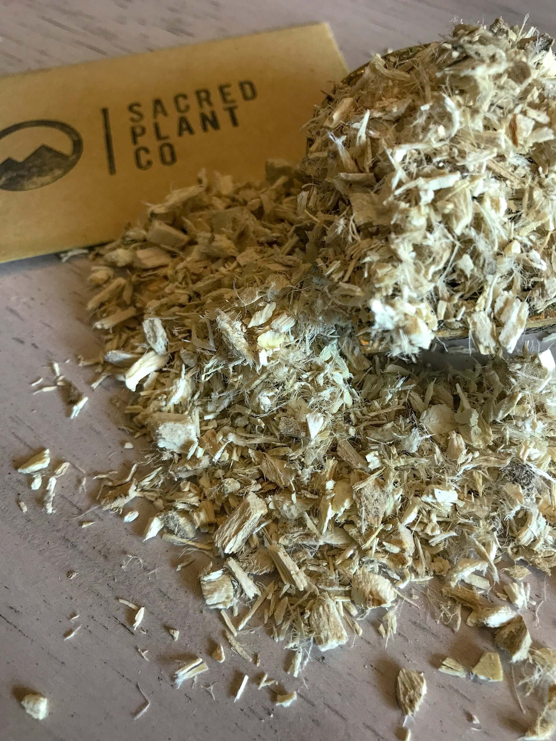 Organic extracted Marshmallow Root displayed on a smooth, light-colored surface, with Sacred Plant Co&