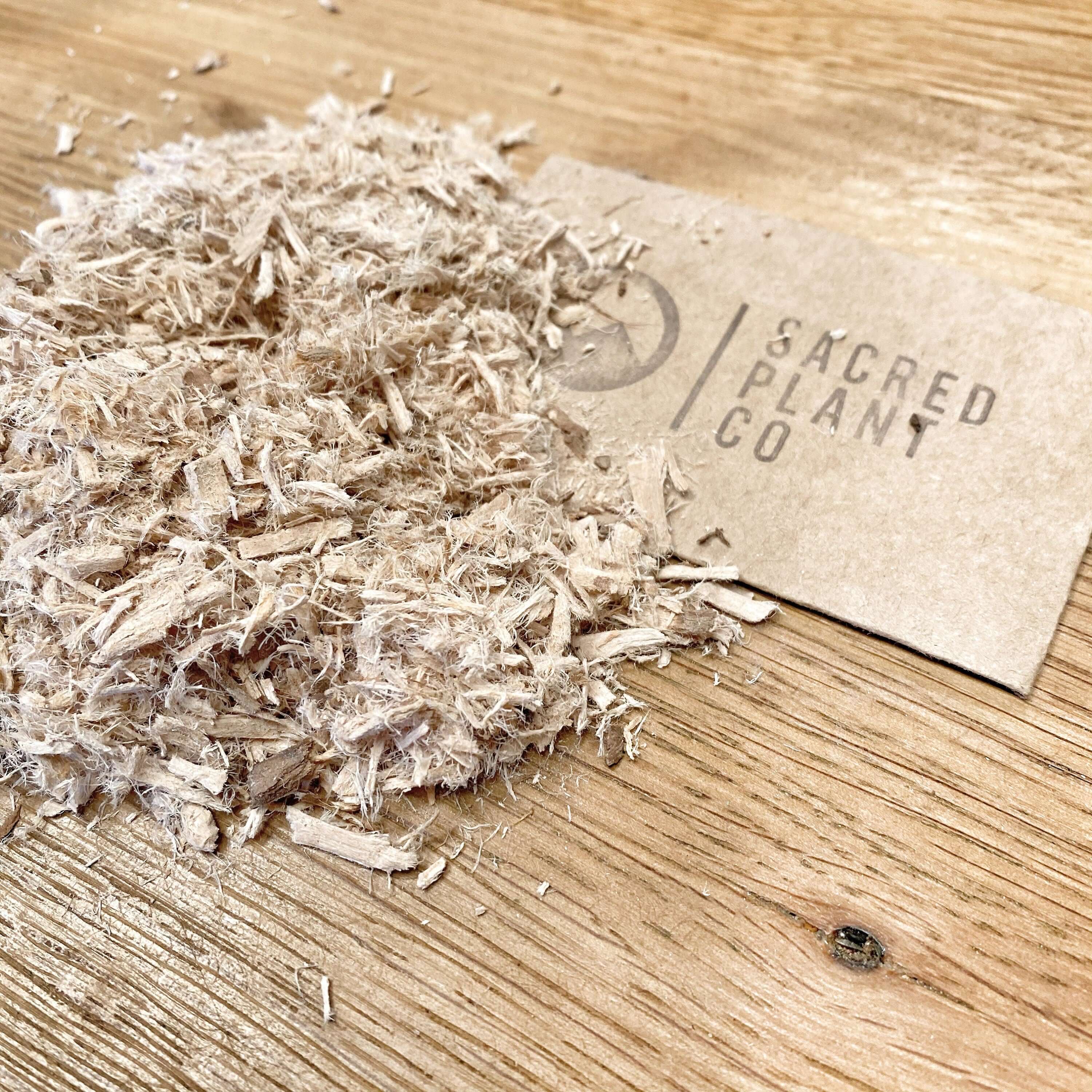 Natural Slippery Elm Bark by Sacred Plant Co, premium shredded texture, light beige color on a wooden surface.