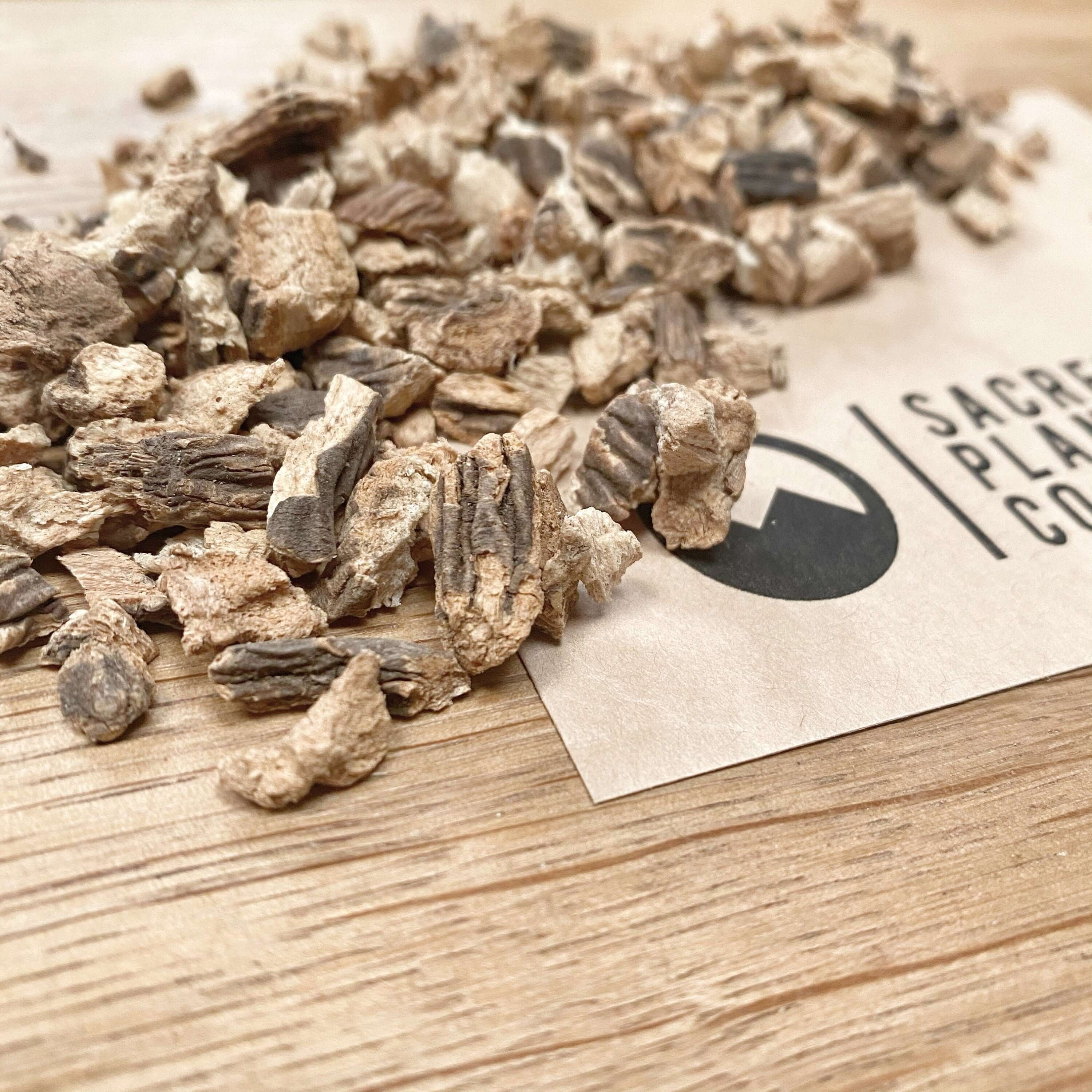 Premium quality Gentian Root displayed with Sacred Plant Co branding, showcasing detailed texture and natural tones on a wooden surface.