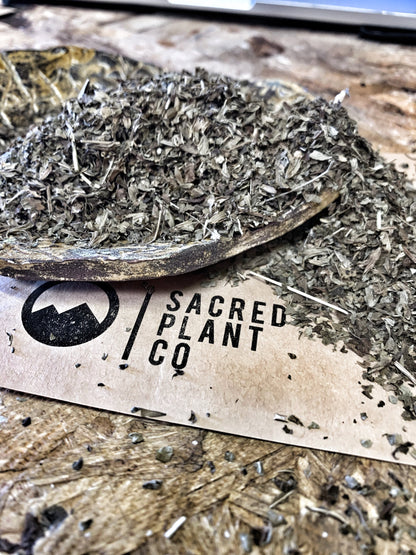 High-quality dried lemon balm from Sacred Plant Co, displayed in a hand-made bowl atop a branded card, showcasing the product&