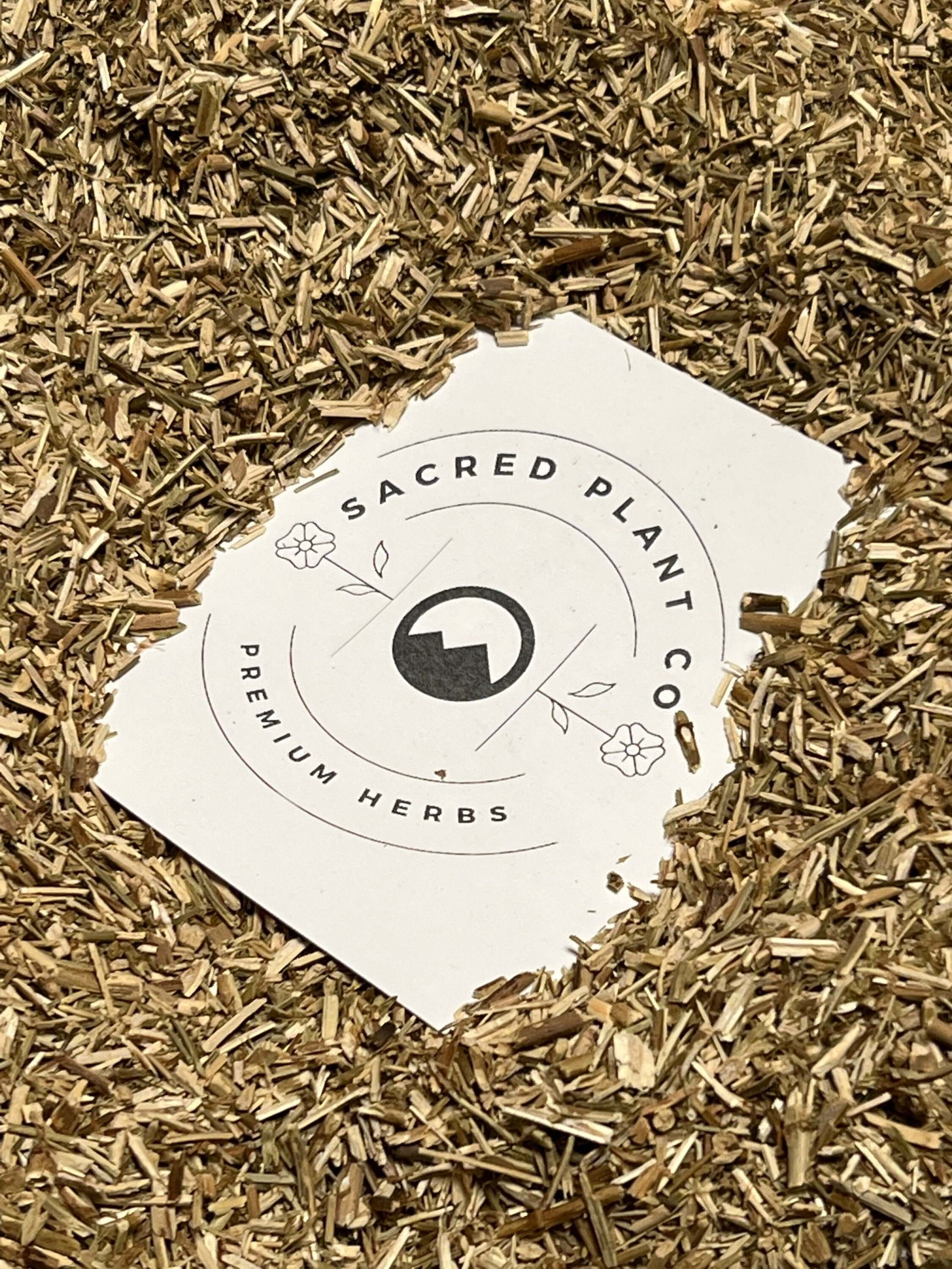 Golden-brown Sacred Plant Co Hyssop Herb with a coarse texture, scattered across a natural beige surface, showcasing premium quality and medicinal benefits.