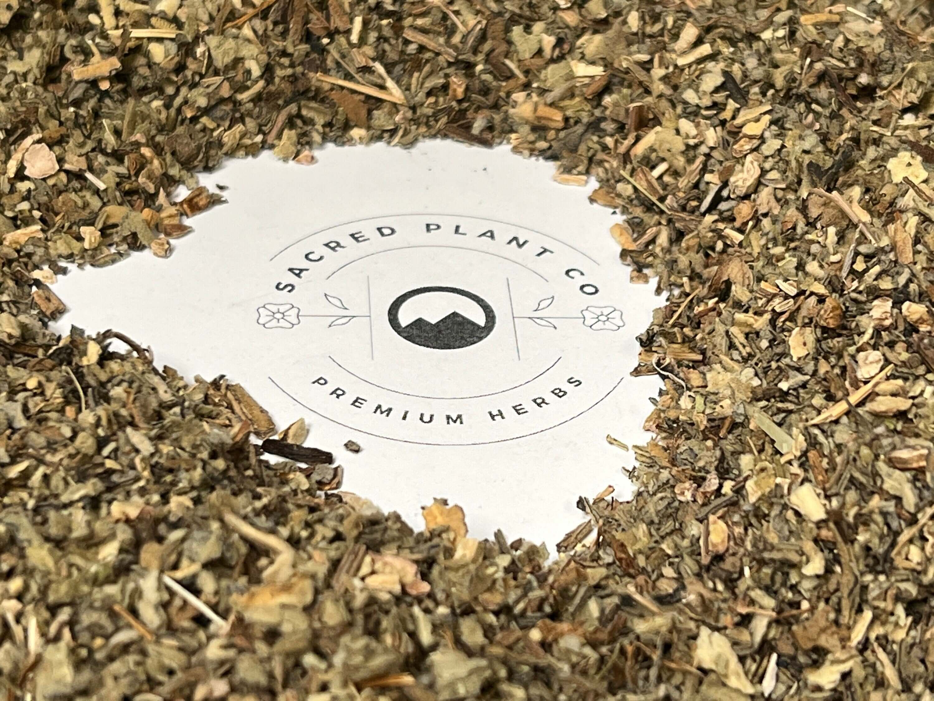 Finely chopped dried Mullein Leaf herbs in earthy tones, arranged around Sacred Plant Co logo, highlighting premium herb quality.