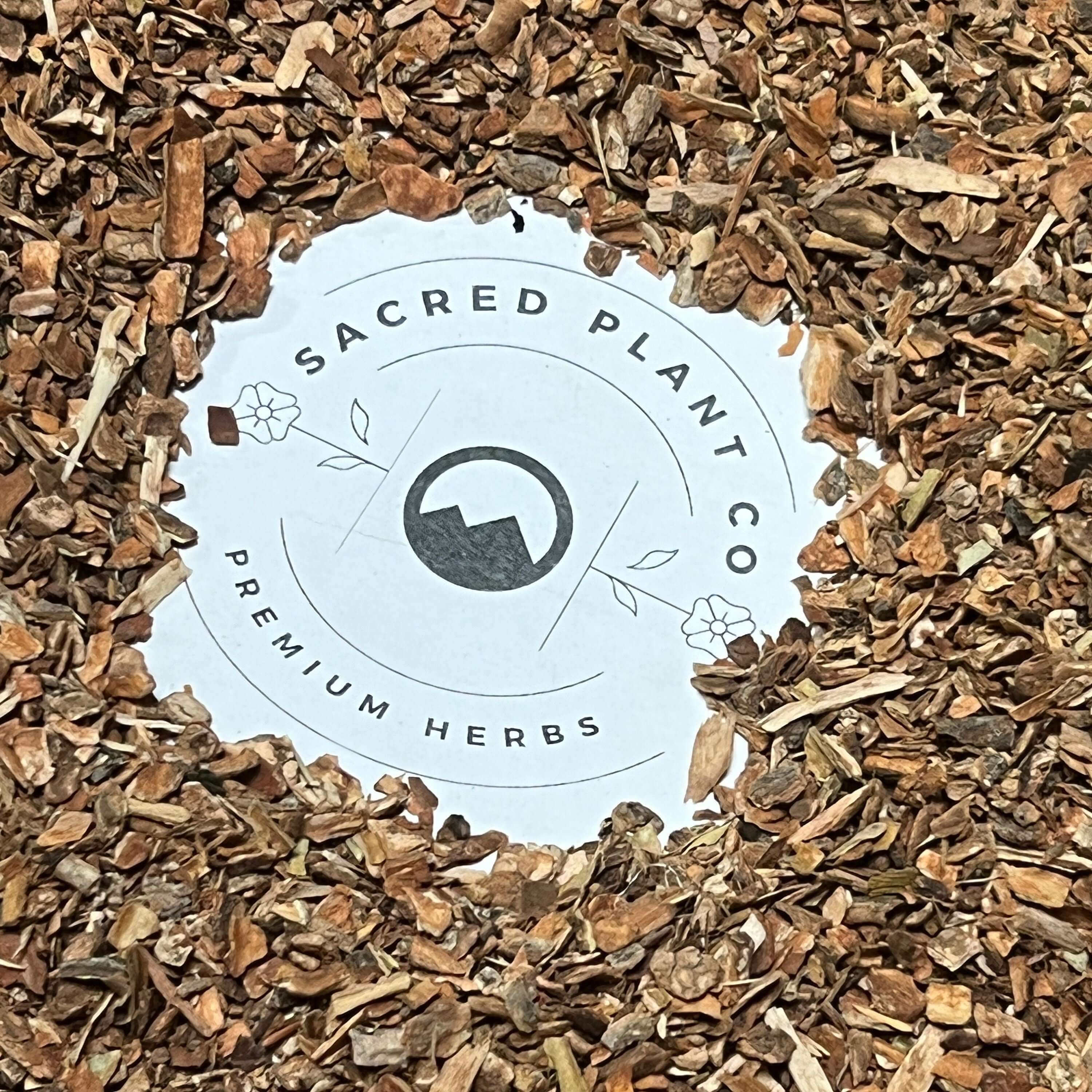 Finely chopped Cramp Bark, in shades of brown, encircling Sacred Plant Co’s logo, highlighting its natural premium quality.