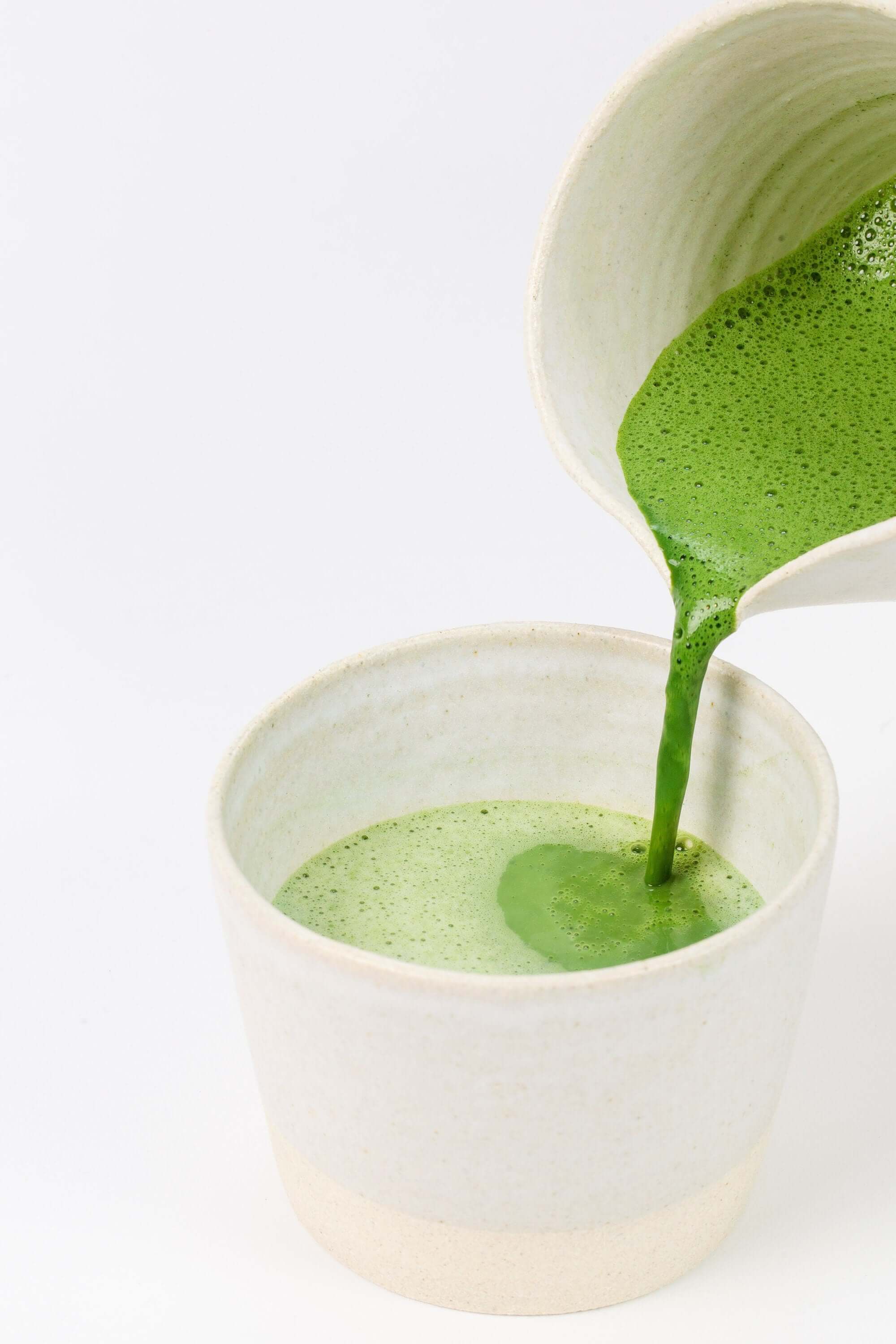 Thick Sasquatch Piss green powder smoothie being poured from a blender into a glass, vibrant green and nutrient-packed health drink by Sacred Plant Co.