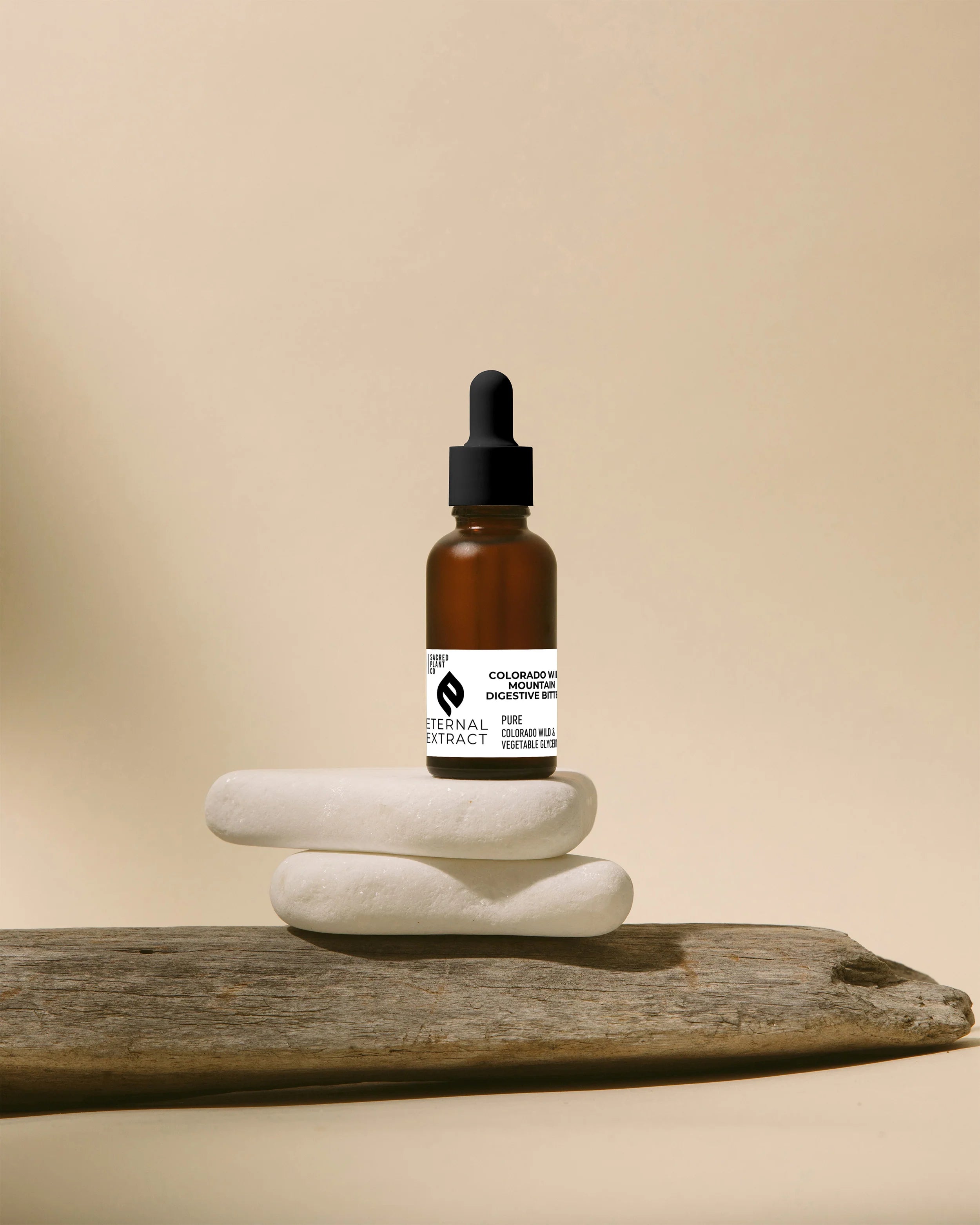 An image featuring a blue glass dropper bottle labeled 'Mountain Digestive Bitters', accompanied by fresh dandelion leaves and roots on a wooden surface, symbolizing the product's herbal composition and connection to nature's healing properties.