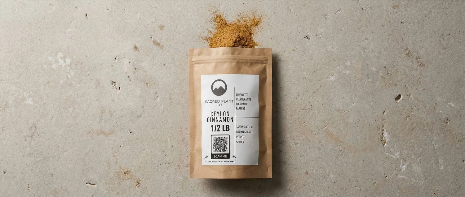 Regeneratively grown Sacred Plant Co Ceylon cinnamon powder spilling from a kraft bag, a potent warming spice used in prosperity rituals.