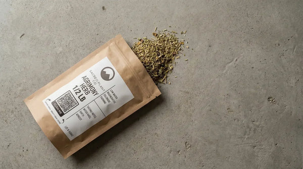 Sacred Plant Co Agrimony herb bag laying on stone dried cut and sifted herb spill out against a natural stone background.