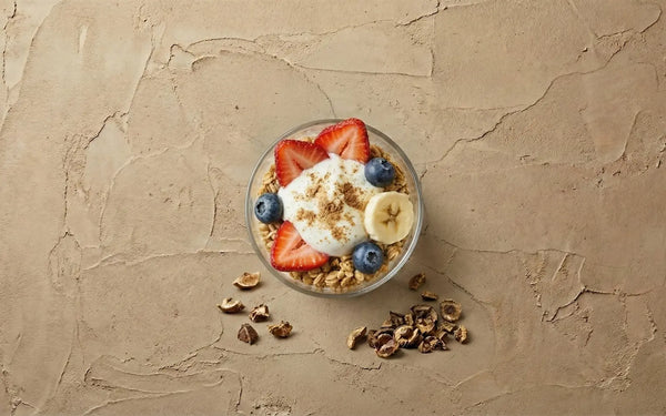 finished immune-boosting yogurt parfait dusted with Amla powder, surrounded by dried Indian Gooseberry pieces.