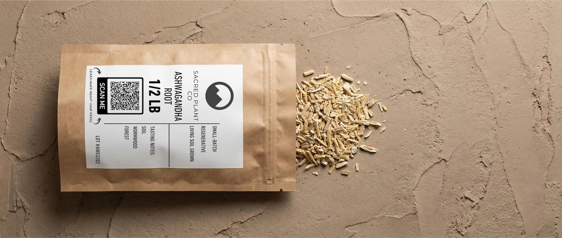 Sacred Plant Co bulk Ashwagandha Root (1/2 lb) packaging on textured earth background, with raw root cuts spilling out to show creamy interior color indicative of high withanolide content from regenerative living soil.