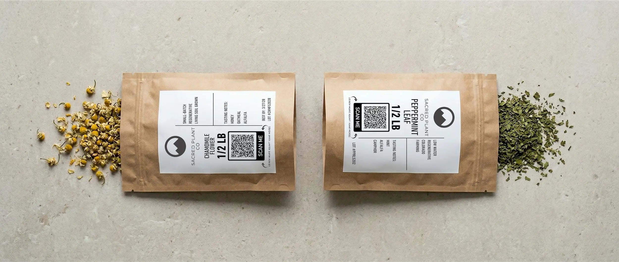 Flat lay of Sacred Plant Co premium loose leaf herbs featuring golden chamomile flowers and bright green peppermint leaf in half-pound kraft pouches with regenerative farming labels.