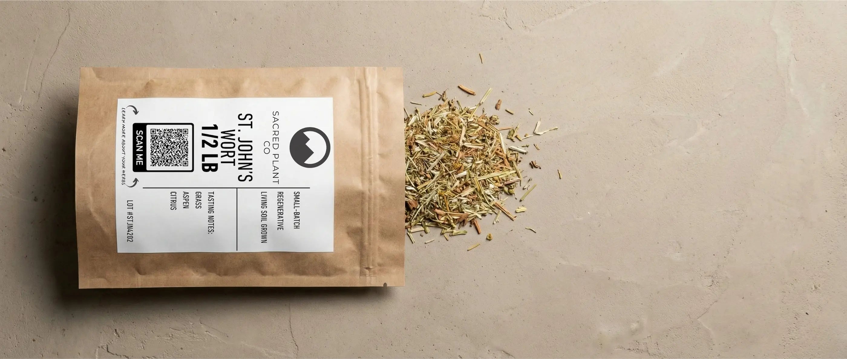 Premium Sacred Plant Co bulk St. John's Wort (1/2 LB) grown in regenerative living soil biology, open kraft paper pouch with dried aerial parts spilling out, featuring a scan me QR code and tasting notes on textured, earth-toned ground.