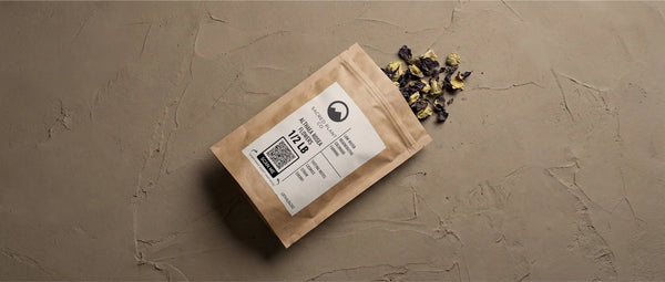 High-quality dried violet hollyhock blossoms rich in anthocyanins and mucilage, displayed next to regenerative farming packaging.