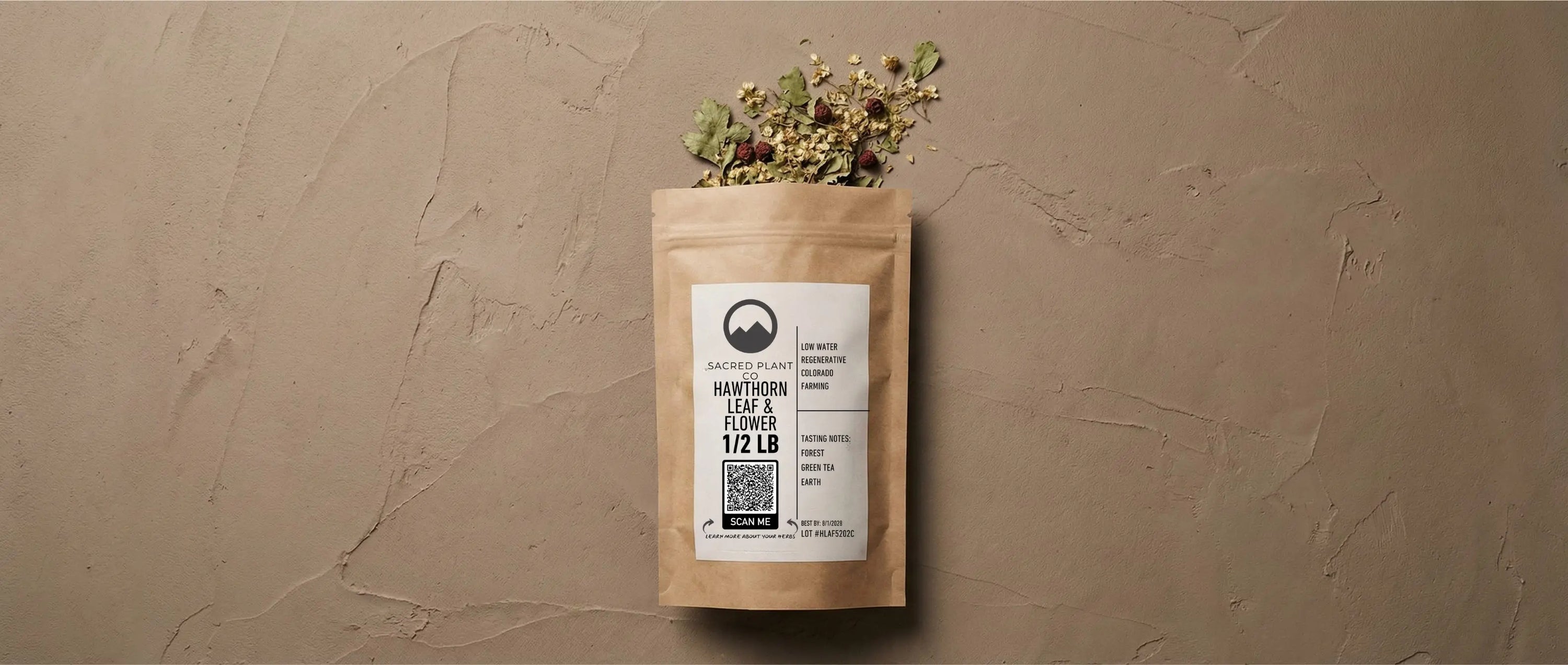 Dried Crataegus monogyna leaf and flower spilling from renewable packaging, illustrating the texture of cut and sifted herbal tea for cardiovascular support.