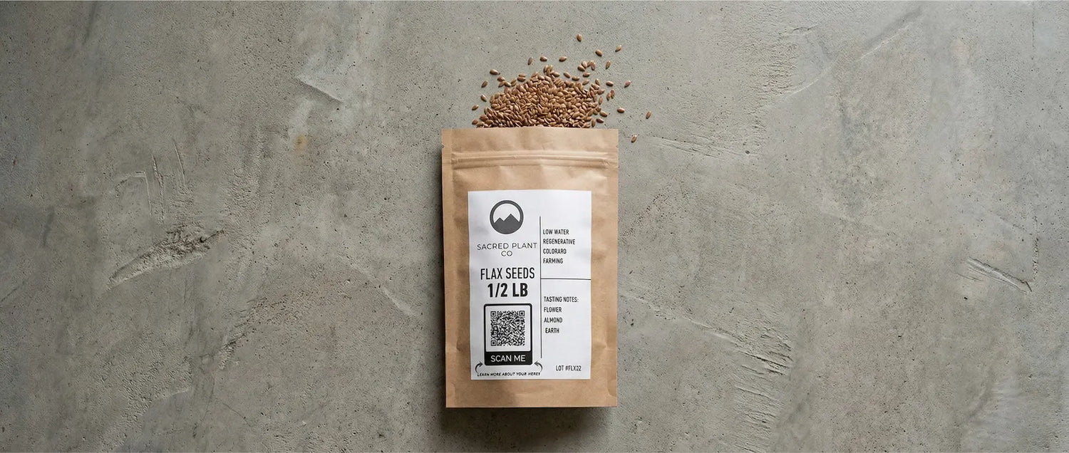 Sacred Plant Co half-pound bag of flax seeds on a concrete surface, displaying the "Scan Me" QR code and tasting notes.