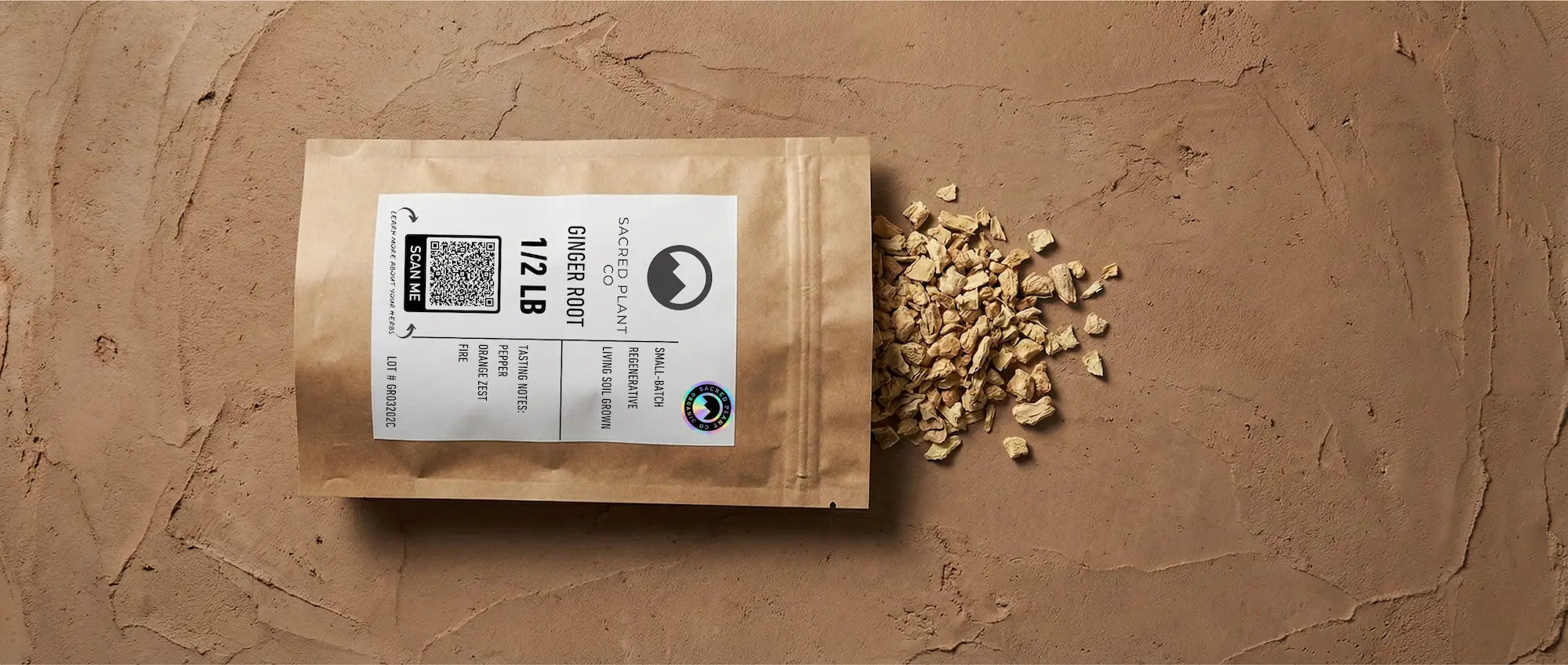 A 1/2 lb bag of Sacred Plant Co dried ginger root spilling golden rhizome chunks onto an earthy surface, showcasing regenerative soil quality.