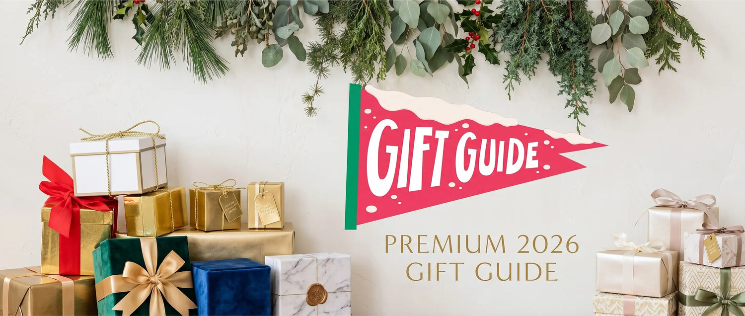 Premium 2026 Gift Guide banner featuring elegantly wrapped presents arranged beneath a garland of botanical winter greenery, representing curated herbal wellness and mindfulness gifts.