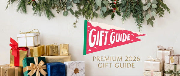 Premium 2026 Gift Guide banner featuring elegantly wrapped presents arranged beneath a garland of botanical winter greenery, representing curated herbal wellness and mindfulness gifts.