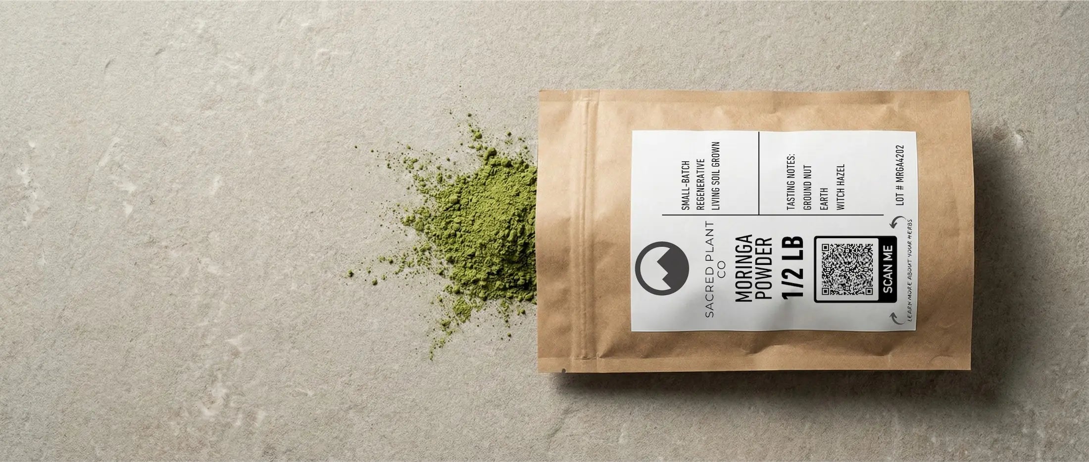Vibrant emerald green Moringa powder spilled next to a kraft paper pouch, showing fine grind and lack of brown oxidation.