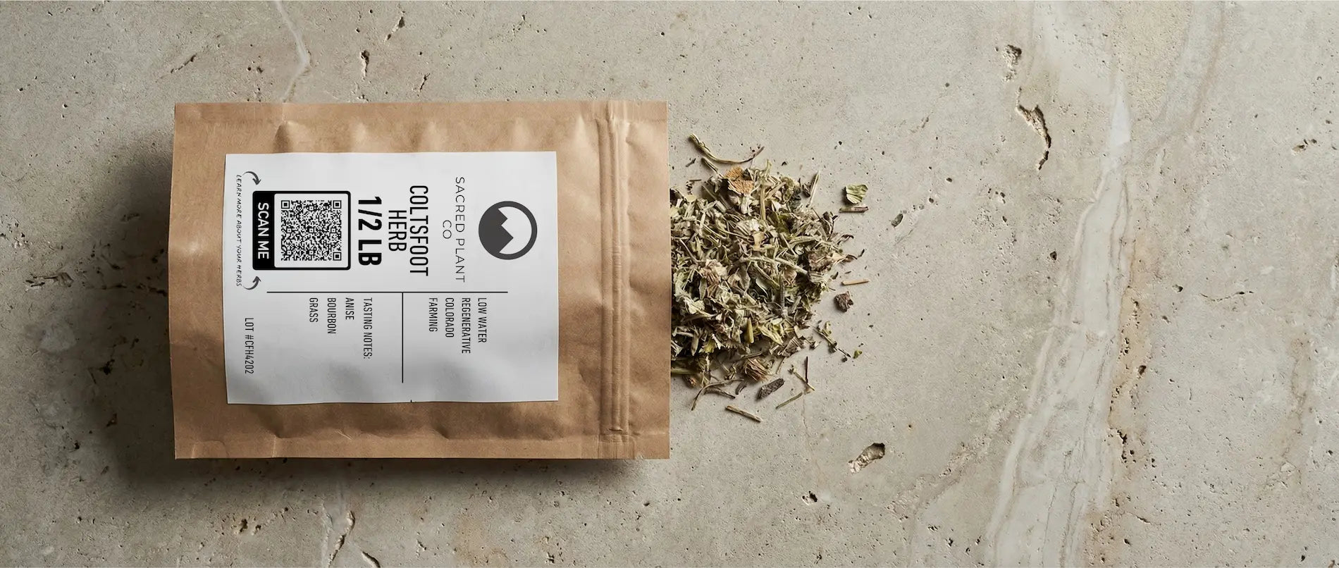 Sacred Plant Co biodegradable packaging containing 1/2 lb of bulk dried Coltsfoot herb (Tussilago farfara) spilled onto a stone surface to show leaf quality.