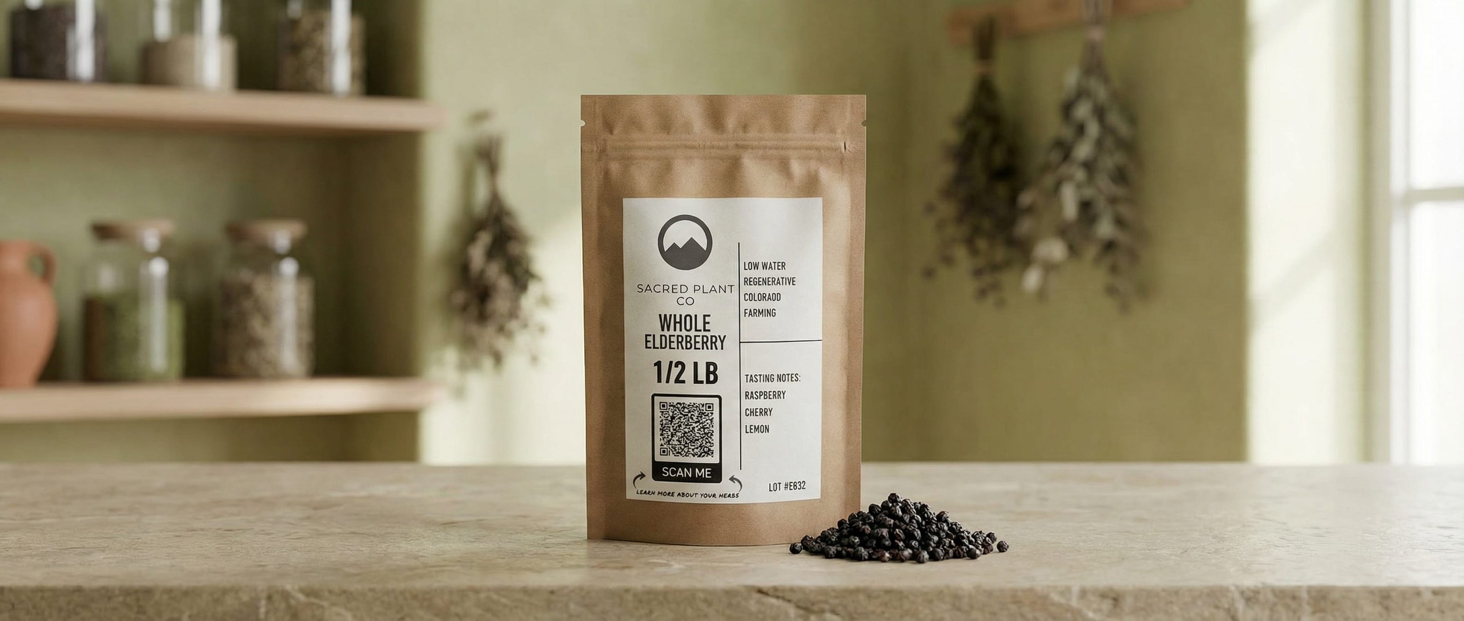 Sacred Plant Co whole dried elderberries in kraft bag standing on stone counter with loose berries