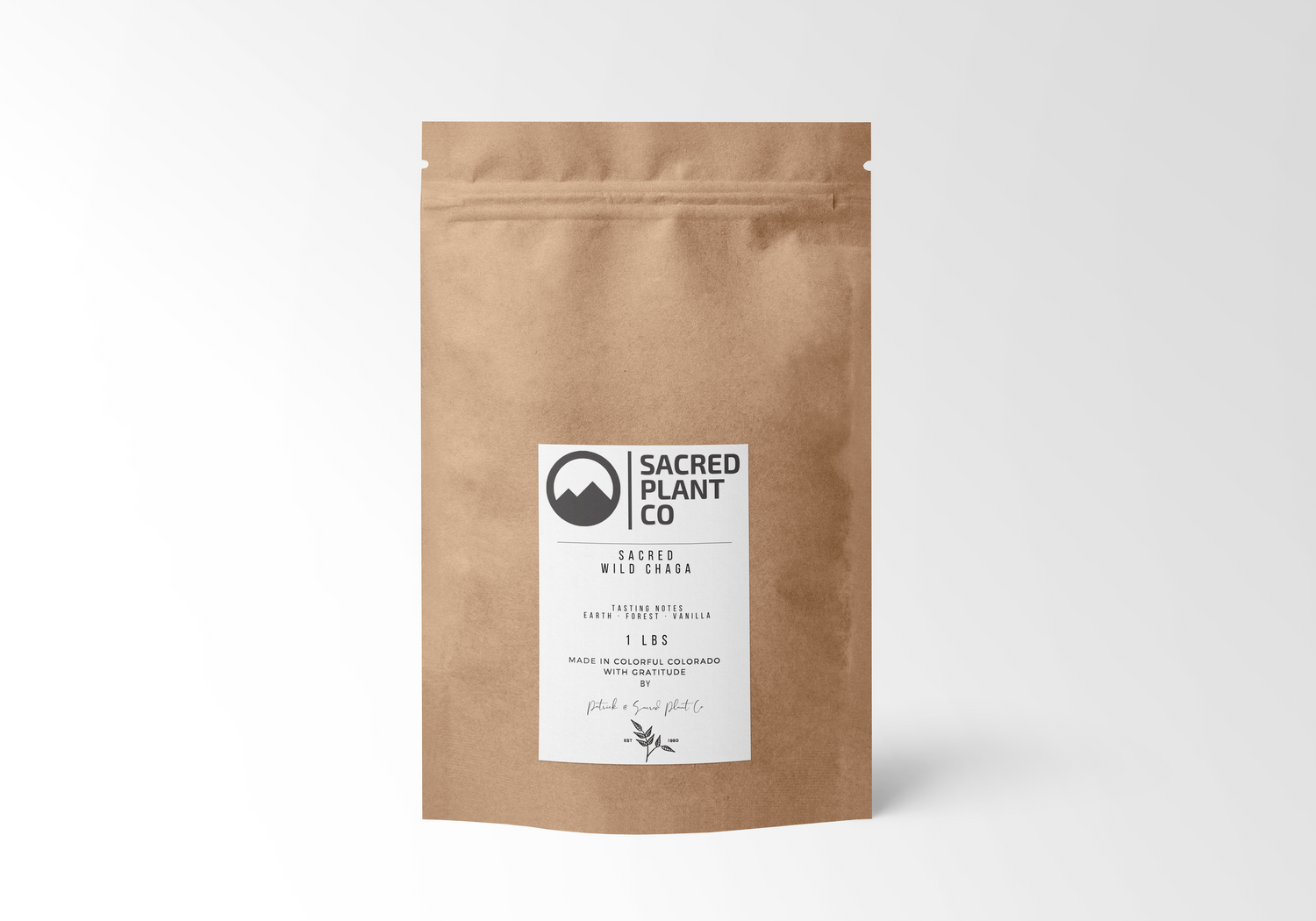 One-pound package of Sacred Wild Chaga Tea from Sacred Plant Co, with tasting notes of earth, forest, and vanilla on the label, crafted with gratitude in Colorado, displayed on a white backdrop.
