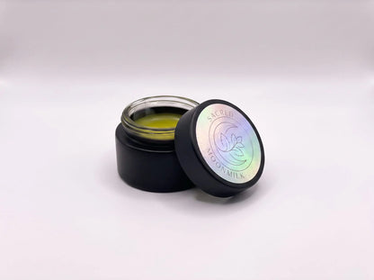 Open jar of Sacred Plant Co Moonmilk Botanical Night Balm showing the soft golden mugwort-infused balm on a clean white background