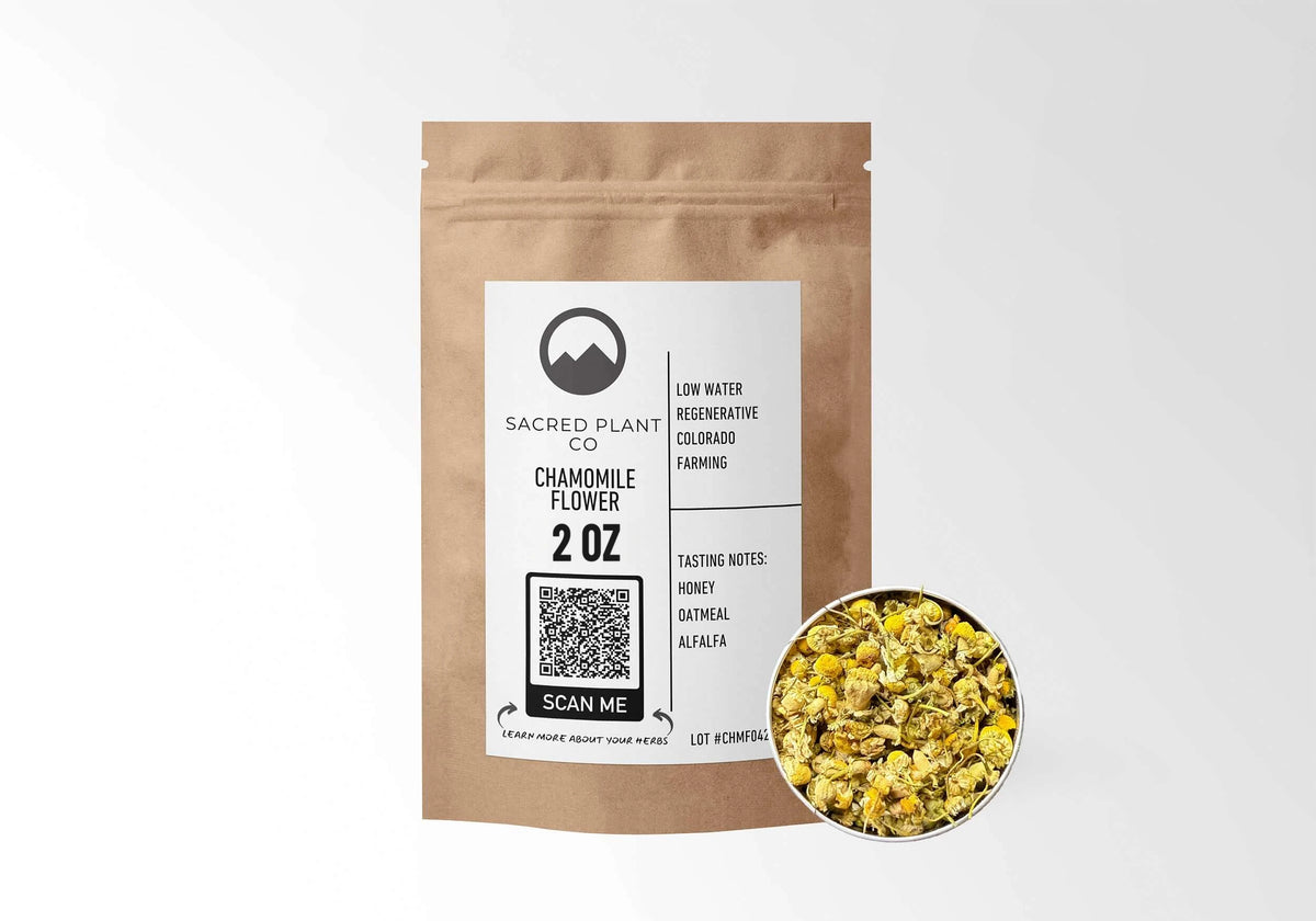 Sacred Plant Co Chamomile Flower 2 oz in a kraft stand-up pouch with a sample of whole dried chamomile flowers in a silver tin, naturally grown with low-water regenerative Colorado farming.