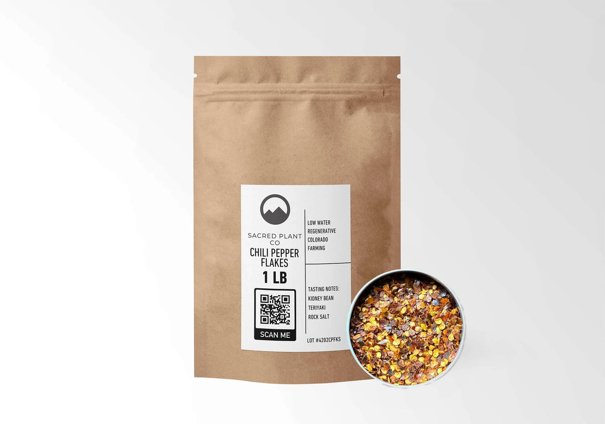Sacred Plant Co Chili Pepper Flakes 1 LB kraft stand-up pouch shown with a sample of the flakes.