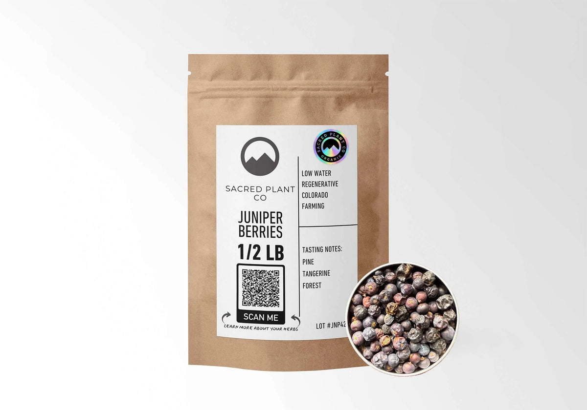 Sacred Plant Co Organic Juniper Berries 1/2 LB in a kraft stand-up pouch with the holographic organic seal on the label and a sample of whole dried juniper berries in a silver tin.