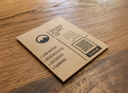 Detailed angled view of Sacred Plant Co Giant Sequoia seed packet on natural wood.