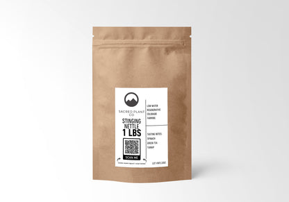 A 1-pound brown kraft paper bag labeled Sacred Plant Co Stinging Nettle, featuring low water regenerative Colorado farming, with tasting notes of spinach, green tea, and turnip. A QR code for more information is also visible.&quot;